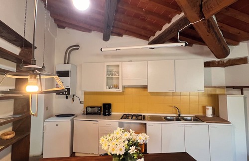 Pieve a Presciano Apartamento | Penthouse with large windows and frescoes in hamlet with pool use